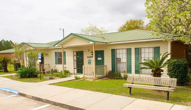 a front view of a house with a yard and potted plants