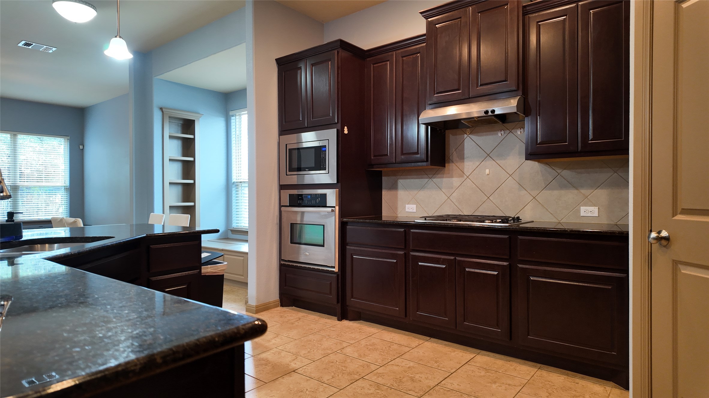 1601 Nelson Ranch Loop Cedar Park, TX 78613 - Photo 7 of 25 Kitchen featuring dark wood finish cabinets, stainless steel appliances, dark stone counters, and tasteful backsplash