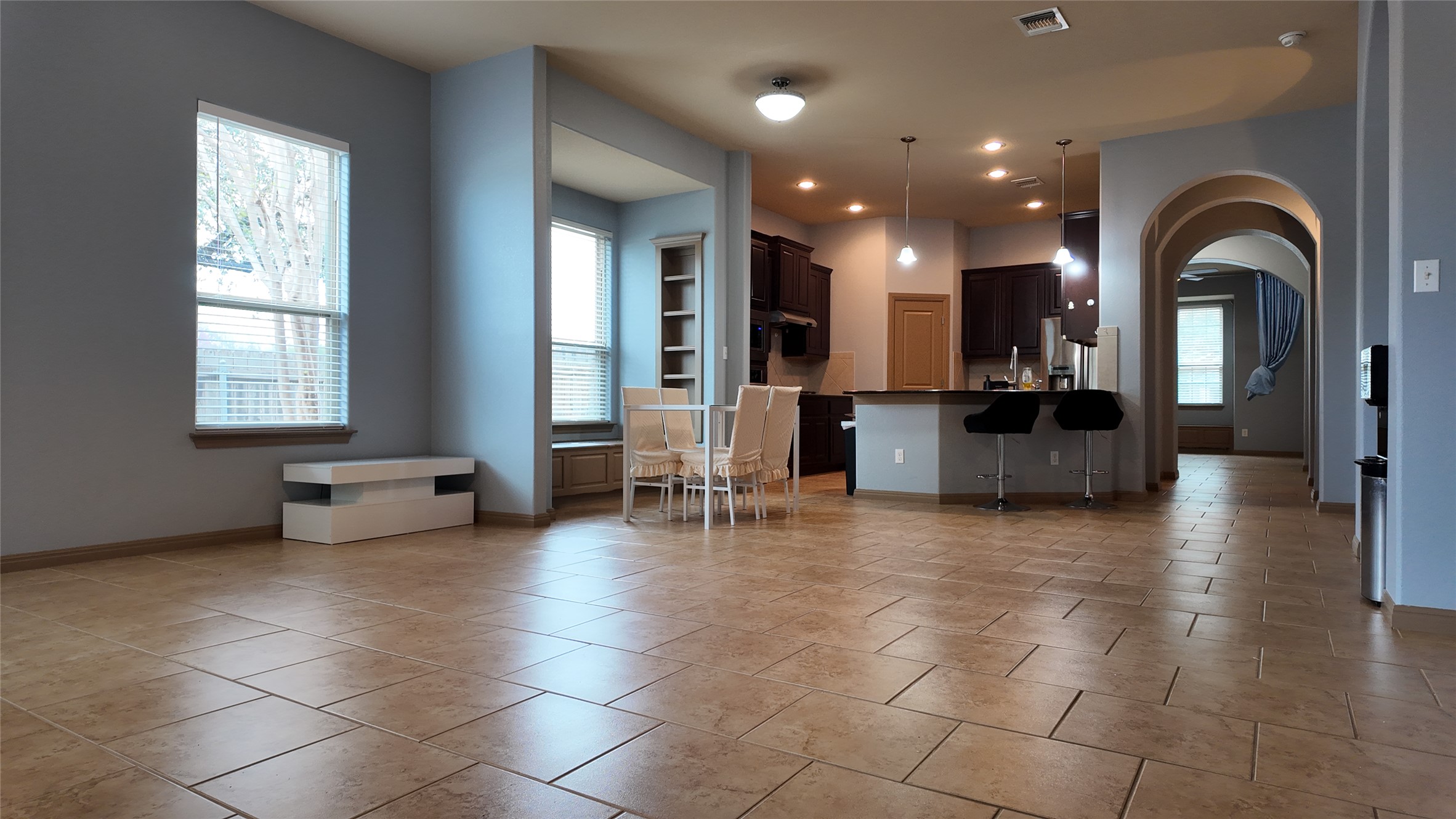 1601 Nelson Ranch Loop Cedar Park, TX 78613 - Photo 25 of 25 Kitchen featuring arched walkways, dark countertops, a kitchen breakfast bar, open floor plan, and stainless steel refrigerator with ice dispenser