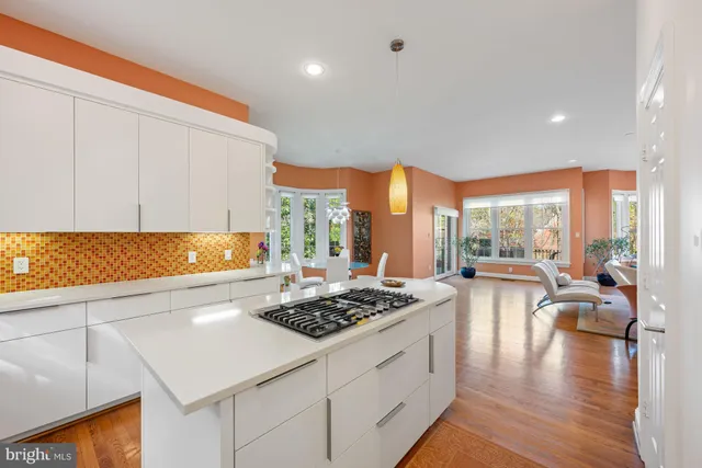 a kitchen with a table chairs stove and wooden floor