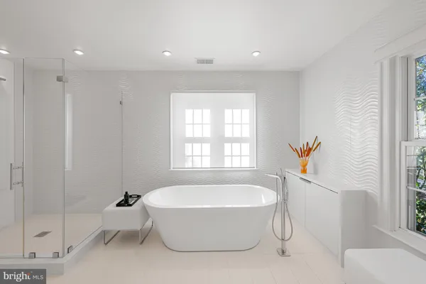 a spacious bathroom with a tub shower and windows