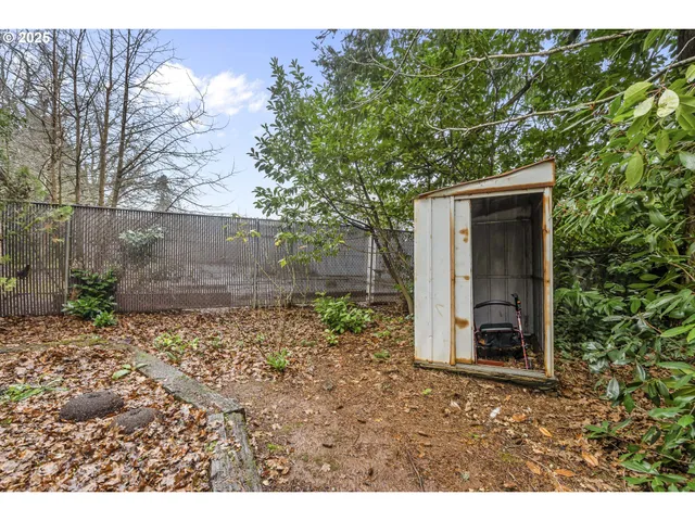 a view of a backyard with table and chairs and wooden fence
