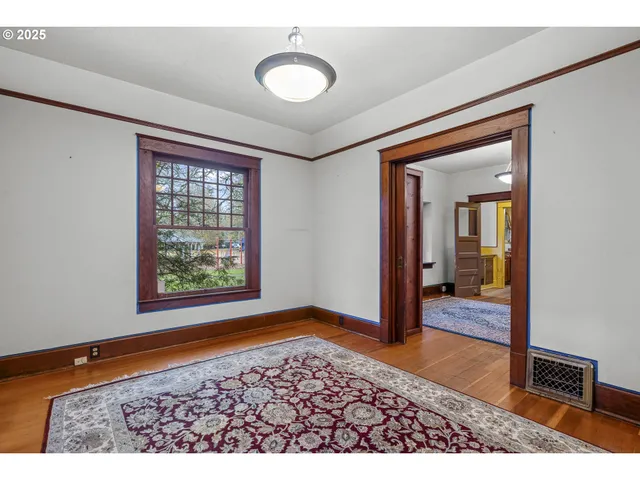 a view of a hallway with wooden floor and chair