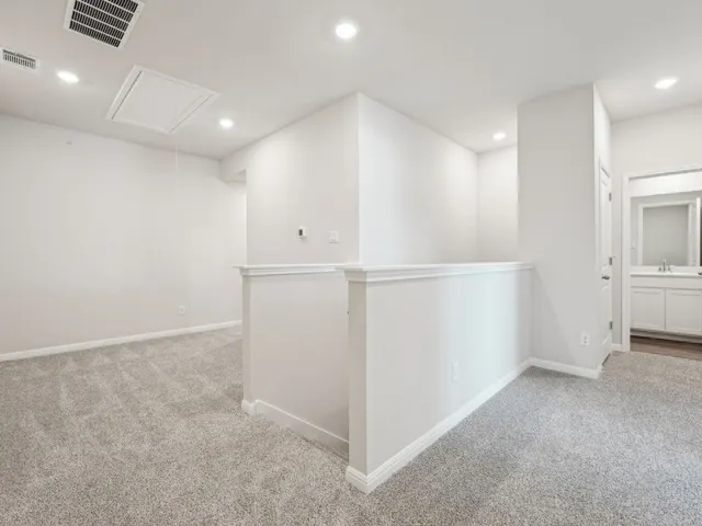 an empty room with a chandelier fan and windows