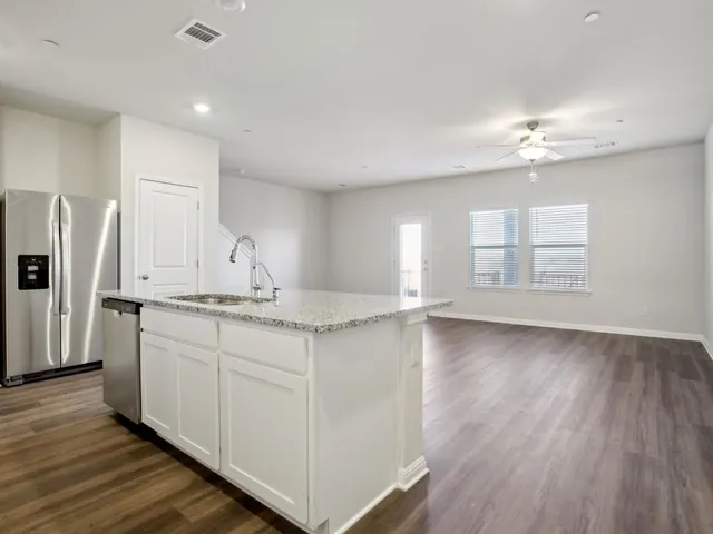 an open kitchen with white cabinets and stainless steel appliances