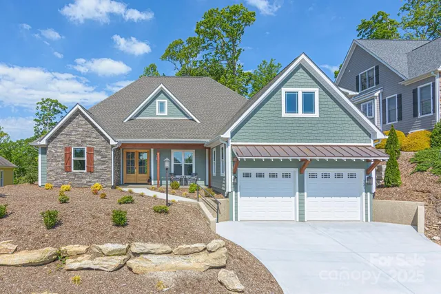 a front view of a house with a yard outdoor seating and garage