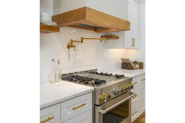 a kitchen with granite countertop a sink stainless steel appliances and cabinets