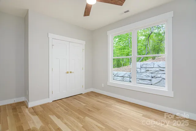 an empty room with windows and closet
