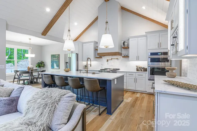 a large living room with stainless steel appliances kitchen island granite countertop furniture and a view of kitchen