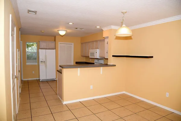 a view of a kitchen with kitchen island wooden floor and stainless steel appliances
