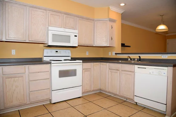 a kitchen with granite countertop white cabinets and white appliances