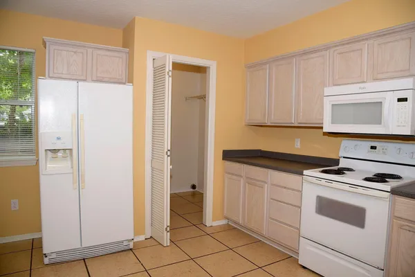 a kitchen with white cabinets and white appliances