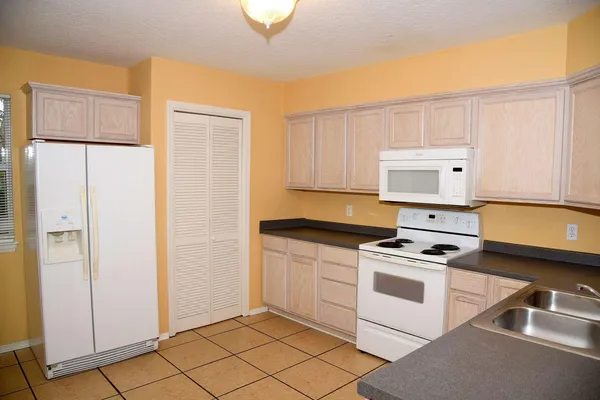 a kitchen with cabinets appliances and a window