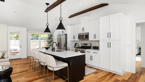 a kitchen with stainless steel appliances kitchen island granite countertop a stove a sink a dining table and chairs