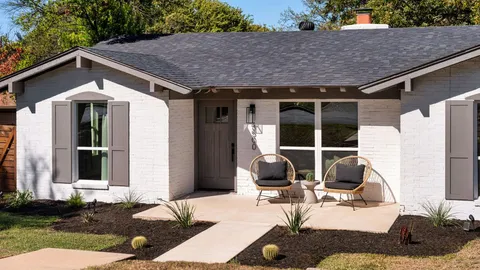 a view of a house with backyard and sitting area