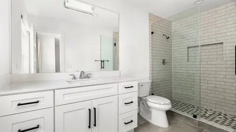 a bathroom with a toilet sink vanity and mirror