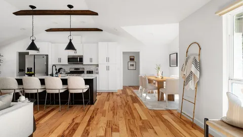a living room with furniture a wooden floor and a chandelier