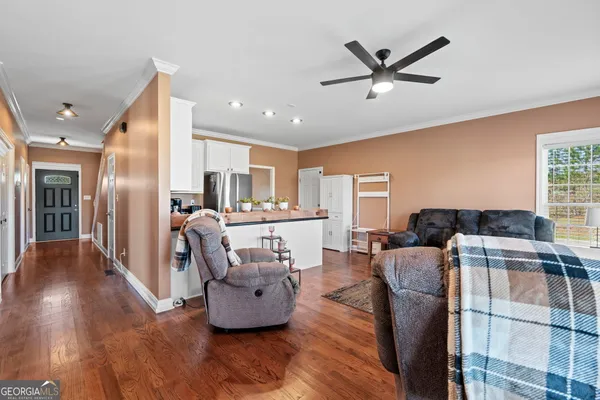 a living room with furniture kitchen view and a refrigerator