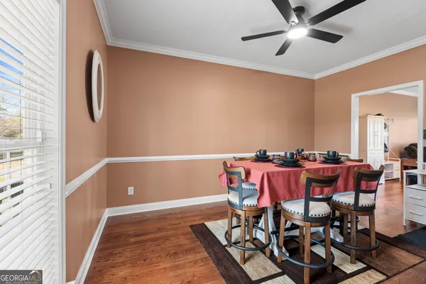 a view of a dining room with furniture and a chandelier fan