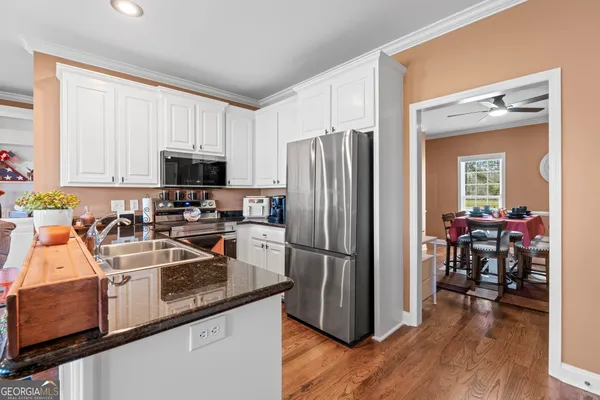 a kitchen with a refrigerator a microwave a sink and cabinets