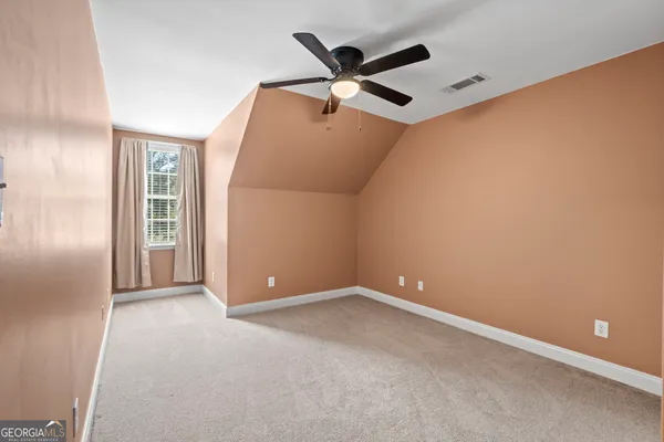 an empty room with closet and a ceiling fan