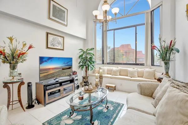 a living room with furniture a large window and a flat screen tv