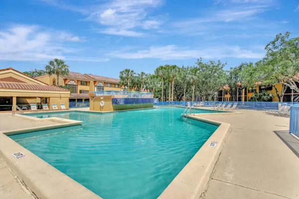 a view of a swimming pool with lawn chairs and a big yard