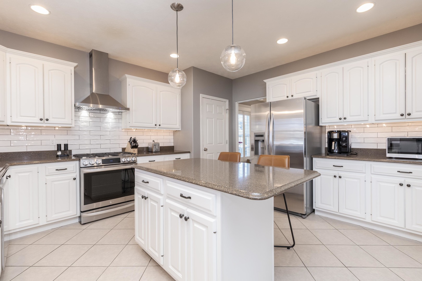 1223 Joy Walk Way Normal, IL 61761 - Photo 5 of 48 a kitchen with stainless steel appliances granite countertop a stove top oven a sink dishwasher a refrigerator and white cabinets with wooden floor