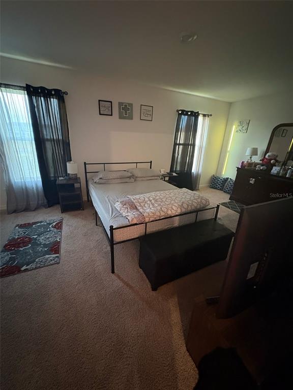 872 Poppy Lane Dundee, FL 33838 - Photo 8 of 13 a bedroom with a bed lamps and window