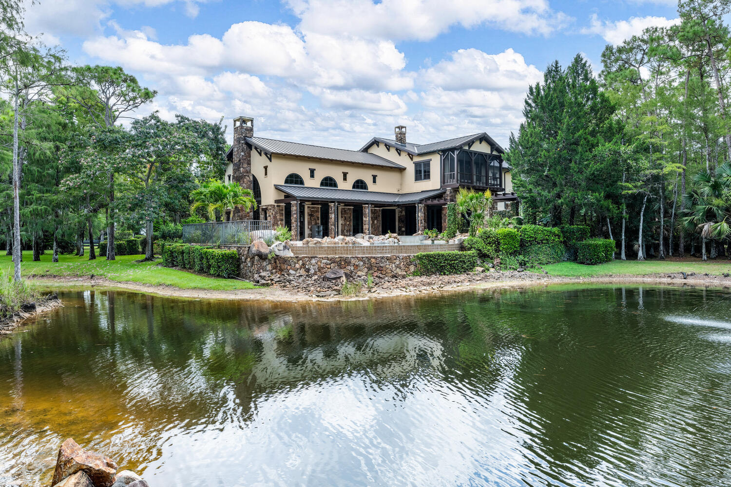 6259 Homeland Road Lake Worth, FL 33449 - Photo 44 of 62 a view of a house next to a lake with a big yard