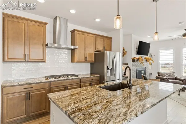 a kitchen with stainless steel appliances granite countertop a sink refrigerator and cabinets
