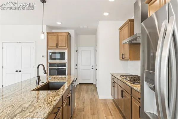 a kitchen with granite countertop a sink stainless steel appliances and cabinets