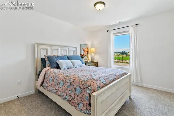 a bed sitting in a spacious bedroom next to a window