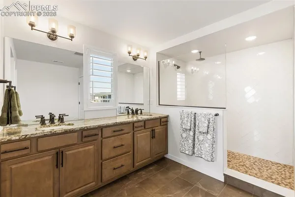 a bathroom with double vanity a sink a mirror a vanity and shower