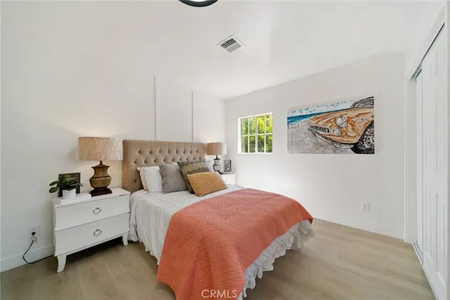 a bed room with two beds and painting on the wall