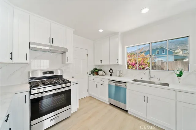 a kitchen with white cabinets stainless steel appliances and sink