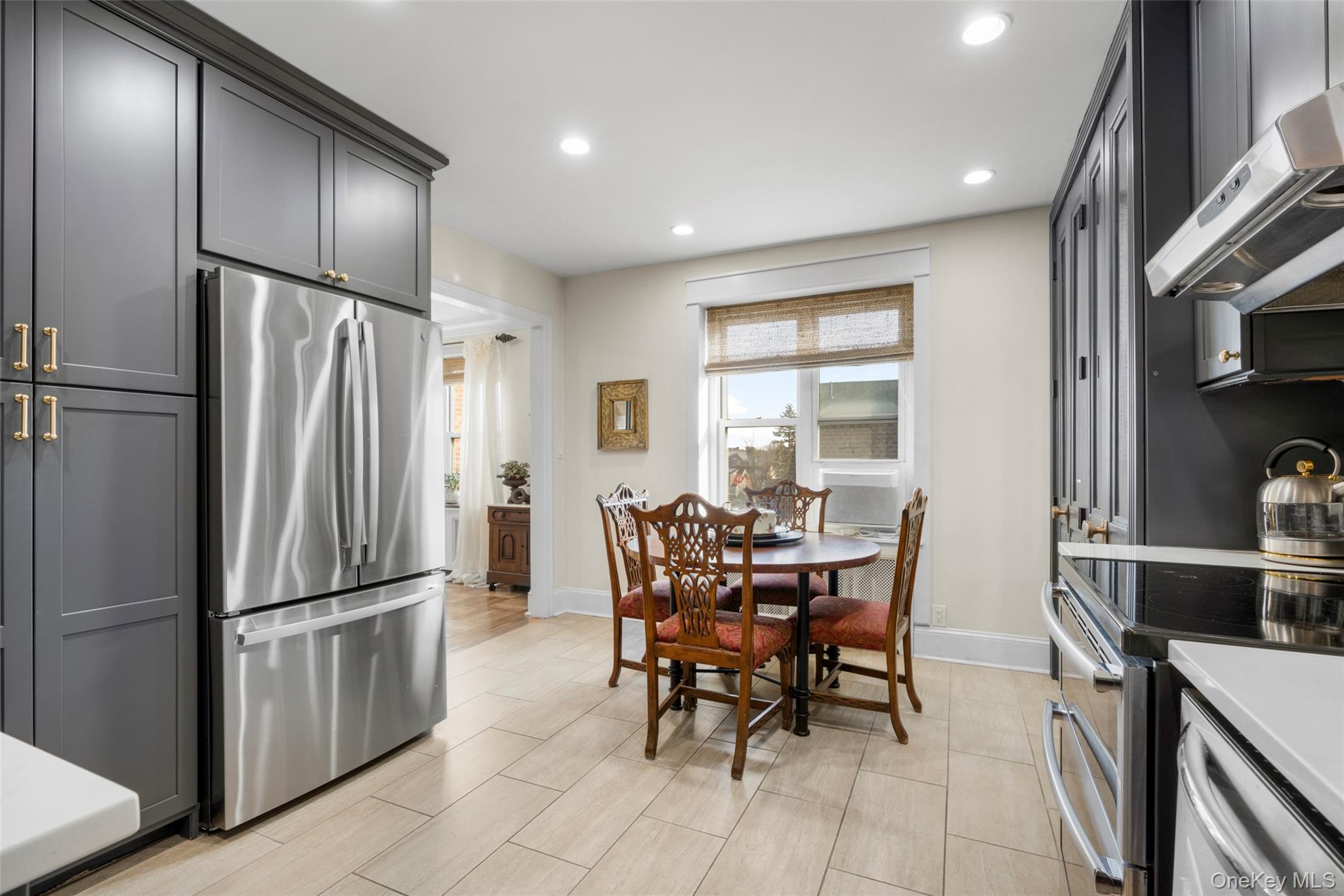 910 Stuart Avenue, Unit 4L Mamaroneck, NY 10543 - Photo 10 of 32 a kitchen with stainless steel appliances granite countertop a dining table chairs refrigerator and sink