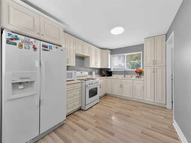 a kitchen with white cabinets and white appliances