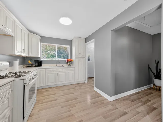 a kitchen with granite countertop white cabinets and white appliances