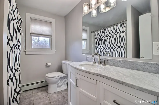 a bathroom with a granite countertop sink a toilet and a mirror