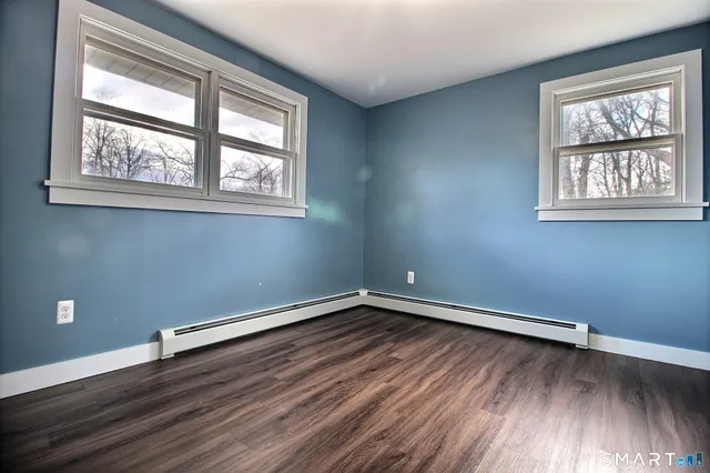 a view of a room with wooden floors and window