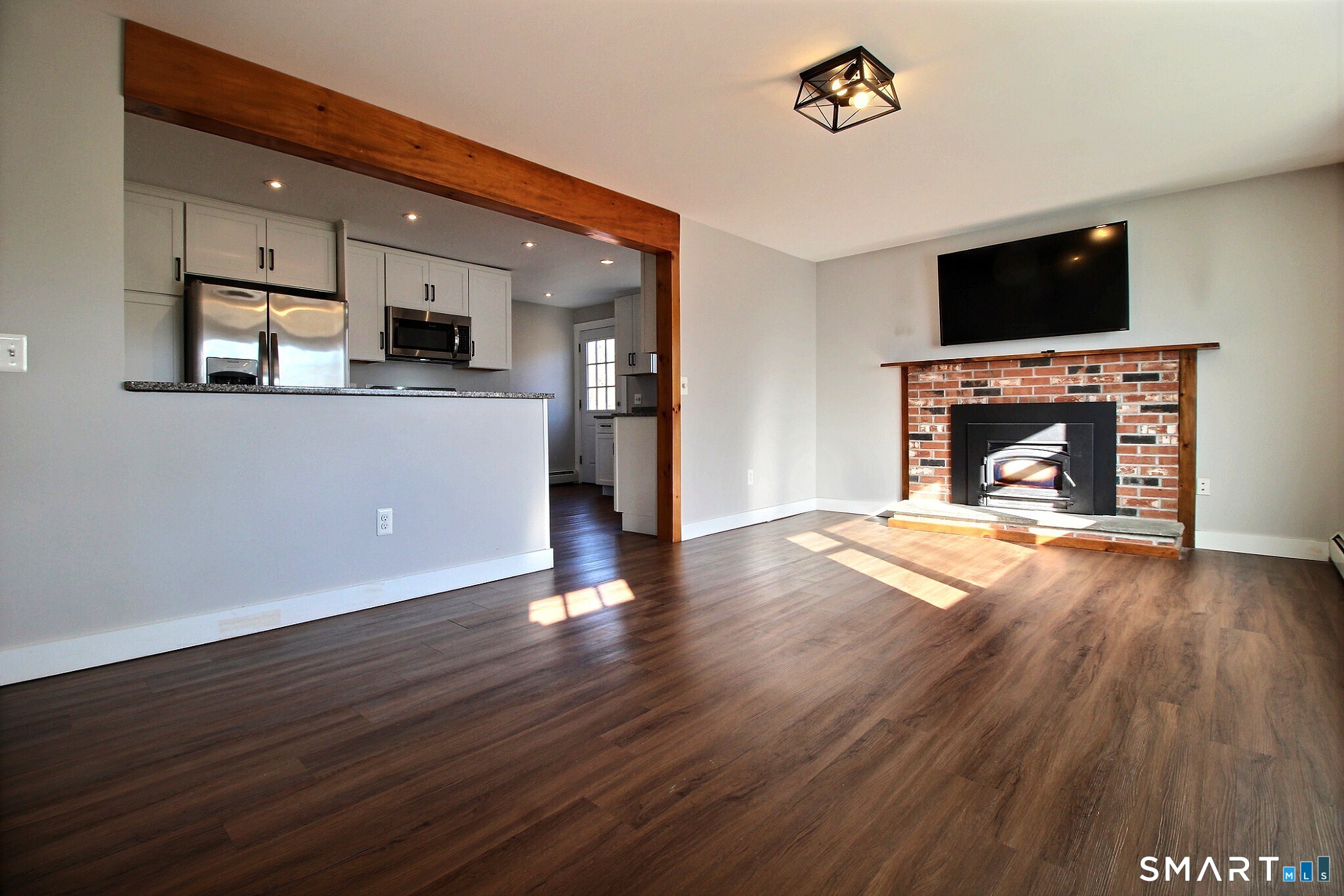 179 North Anguilla Road Stonington, CT 06379 - Photo 8 of 21 a living room with stainless steel appliances wooden floor and a fireplace