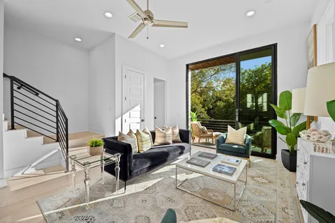 a living room with furniture potted plant and a large window