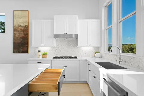 a kitchen with a sink stove and white cabinets