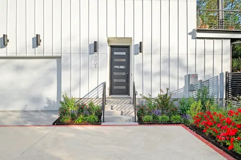 a front view of a house with a garden and plants