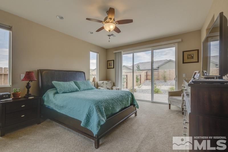 9840 Nahar Lane Reno, NV 89521 - Photo 11 of 25 a spacious bedroom with a bed and a chandelier