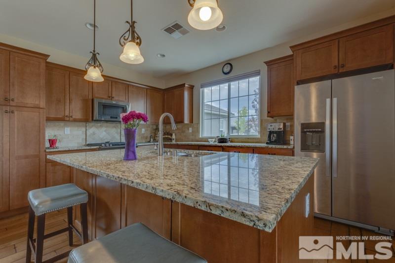 9840 Nahar Lane Reno, NV 89521 - Photo 6 of 25 a kitchen with stainless steel appliances granite countertop a sink a microwave a refrigerator and a stove