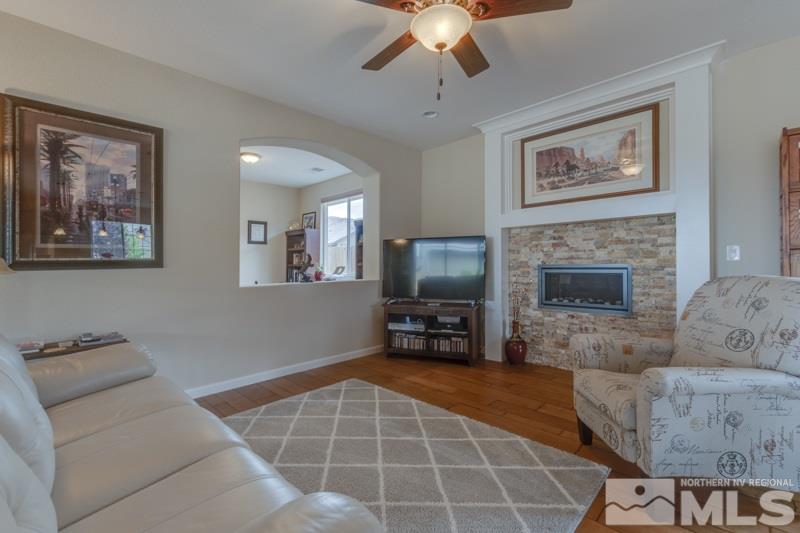 9840 Nahar Lane Reno, NV 89521 - Photo 7 of 25 a living room with furniture a flat screen tv and a fireplace