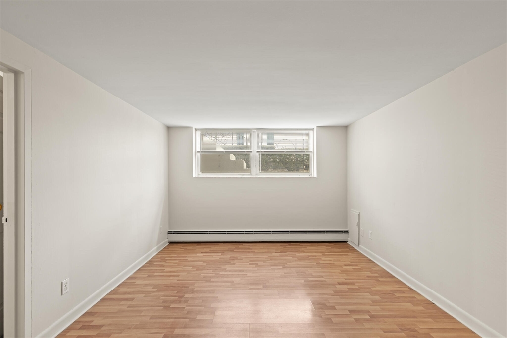12 Central Avenue, Unit 1 Danvers, MA 01923 - Photo 7 of 25 an empty room with wooden floor and windows