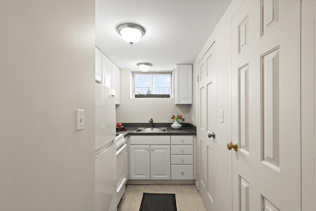 12 Central Avenue, Unit 1 Danvers, MA 01923 - Photo 10 of 25 a kitchen with stainless steel appliances a stove and a refrigerator